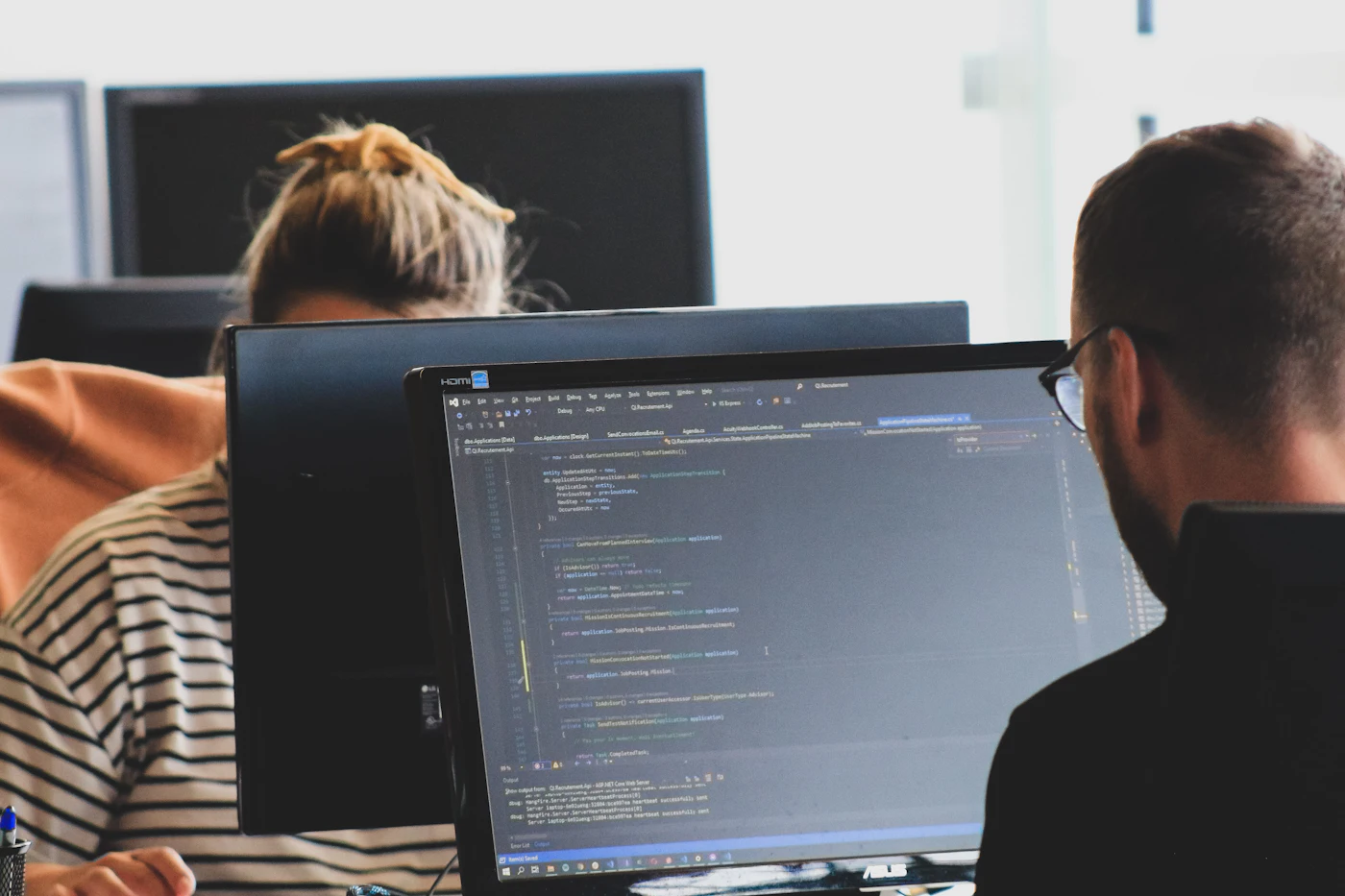 Software developers writing code together for a custom business software project